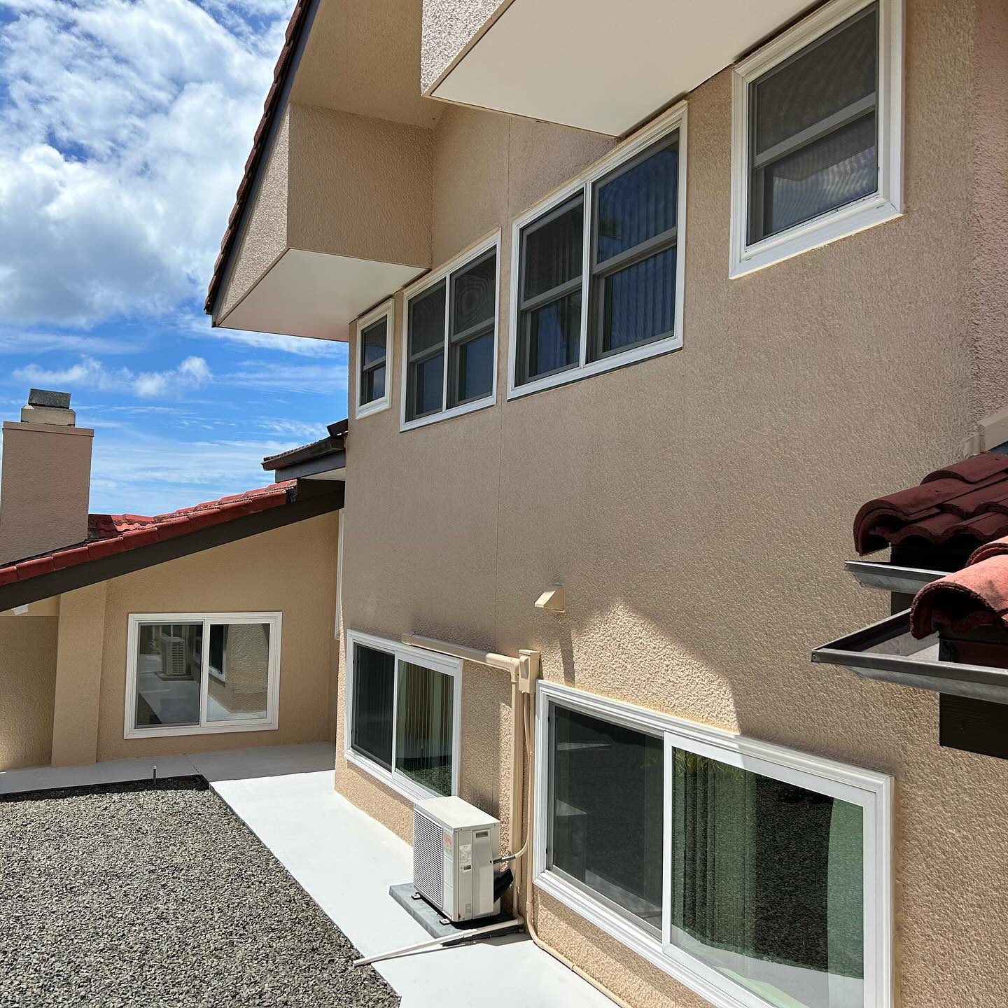Side elevation of an Oahu home after a full stucco exterior repaint in warm tan