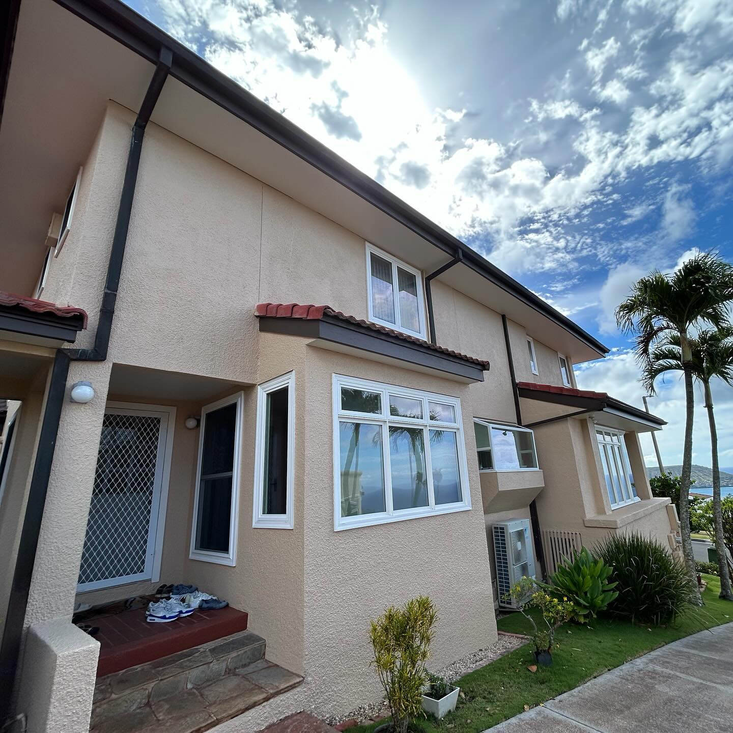 Two-story Oahu townhome exterior repaint with crisp white trim and ocean view