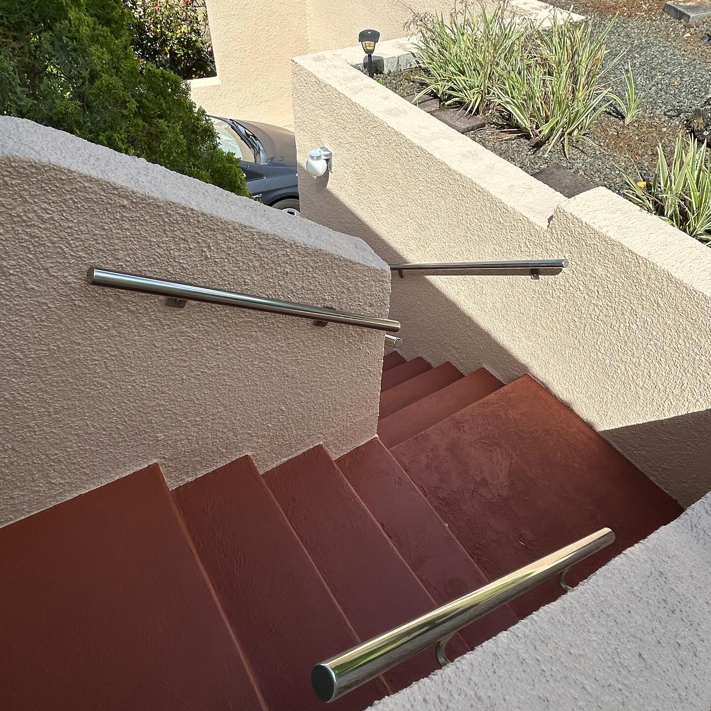Terracotta non-slip coating on exterior concrete stairs with stainless handrails on Oahu